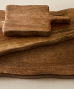 Two wooden cutting boards with a rustic finish on a light background